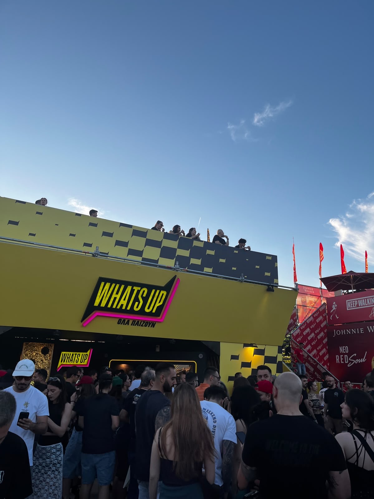 Crowd outside the WhatsUp booth at sunset