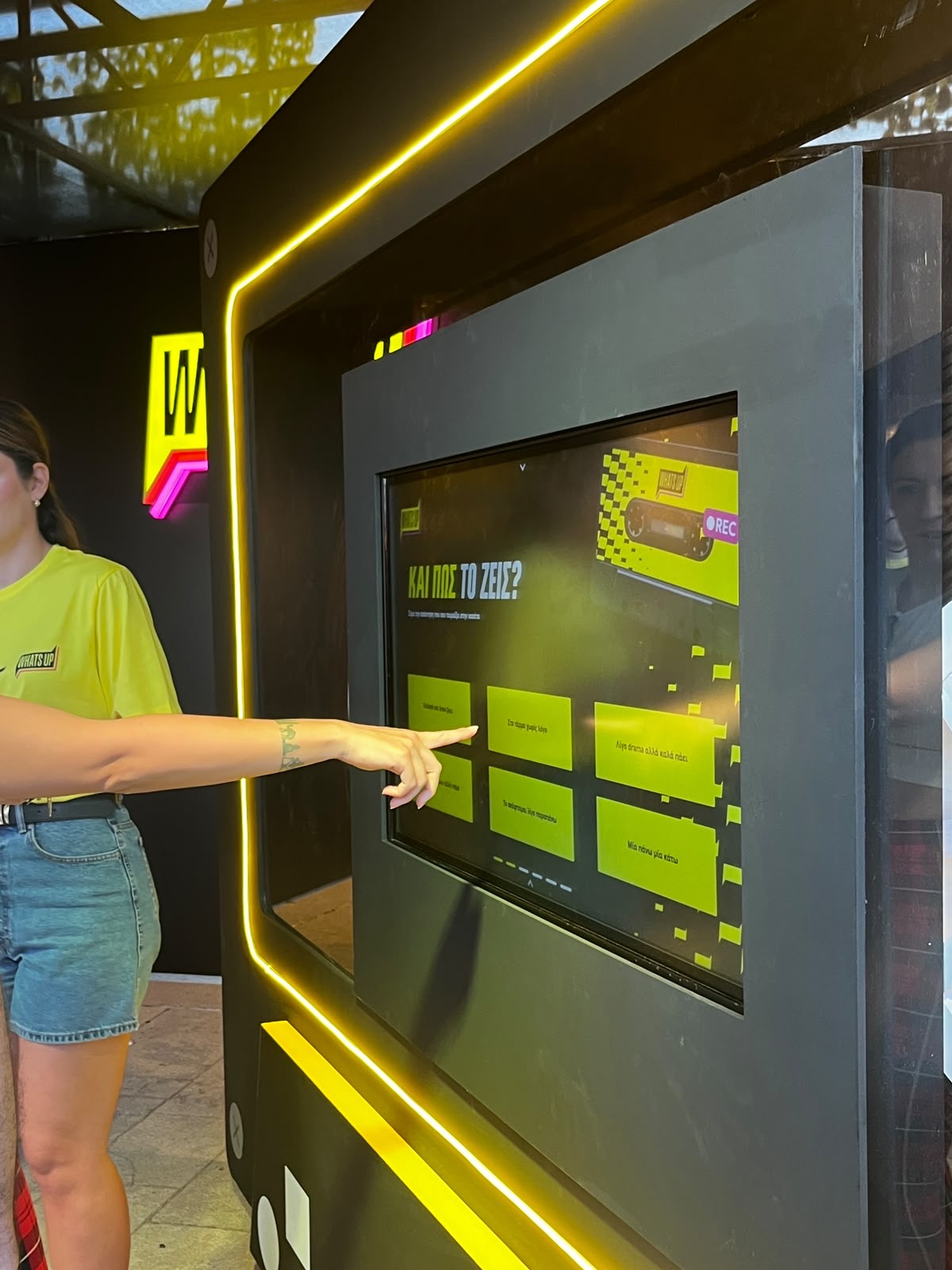 Booth staff pointing at the cassette touchscreen